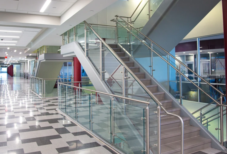 Modern steel and glass railing design for stairs and balcony in a school interior.