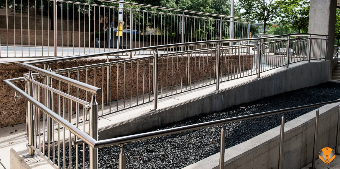 Stainless steel railings along accessible outdoor ramp and walkway.