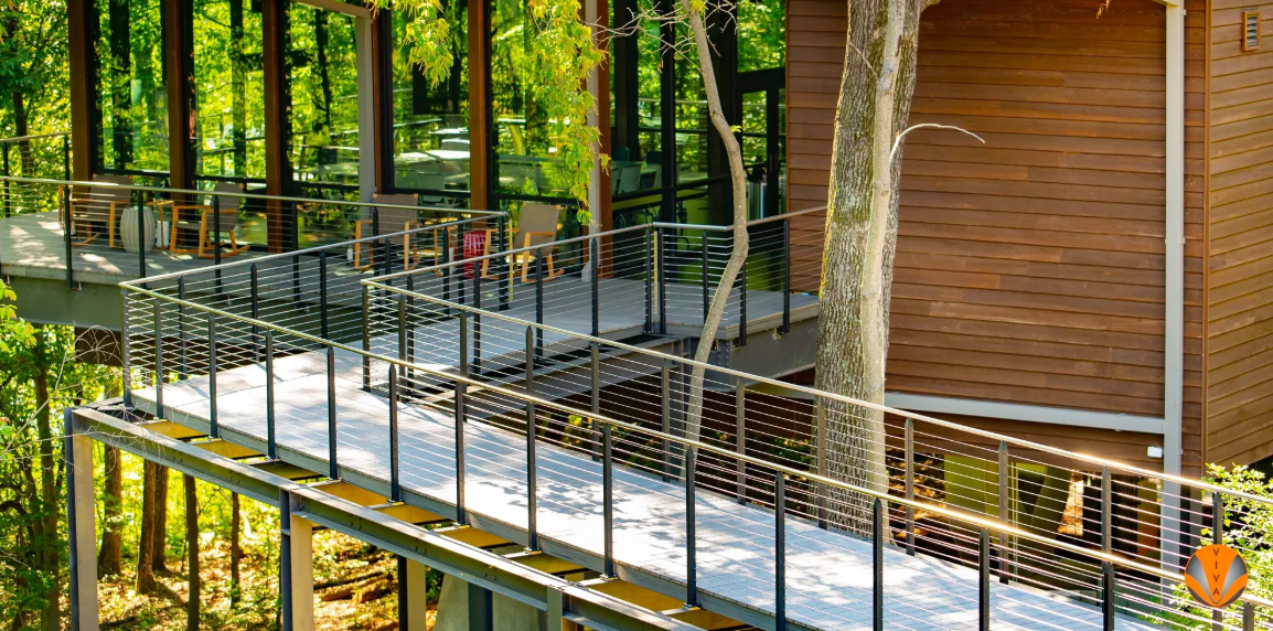 Modern staircase with wood steps, glass railings, and metal handrails in commercial interior.
