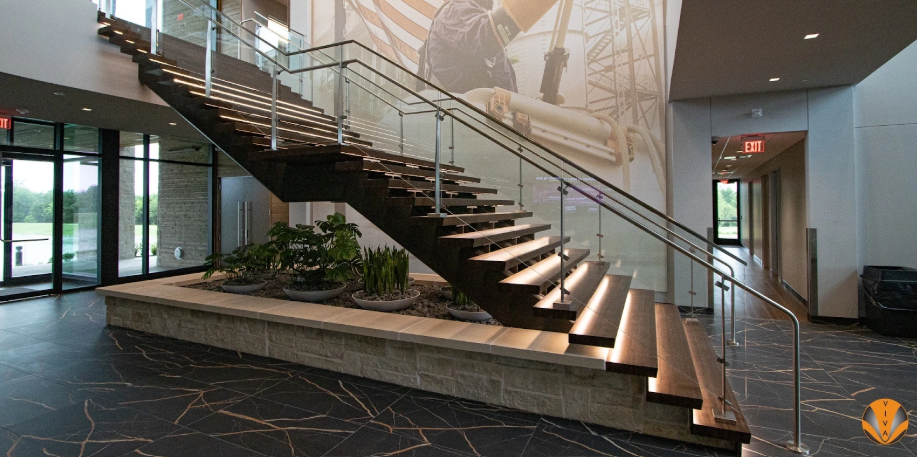 Contemporary floating wood staircase with glass panels and metal handrails.