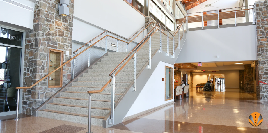 Inviting interior staircase featuring wood handrails and stone accents in a bright lobby.