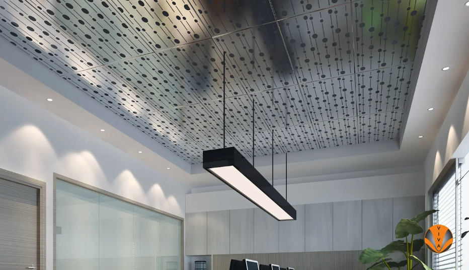 Modern office with perforated architectural ceiling panels and suspended lighting.