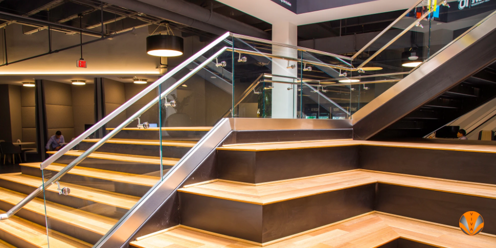 Modern staircase with glass railings and tiered wooden seating.
