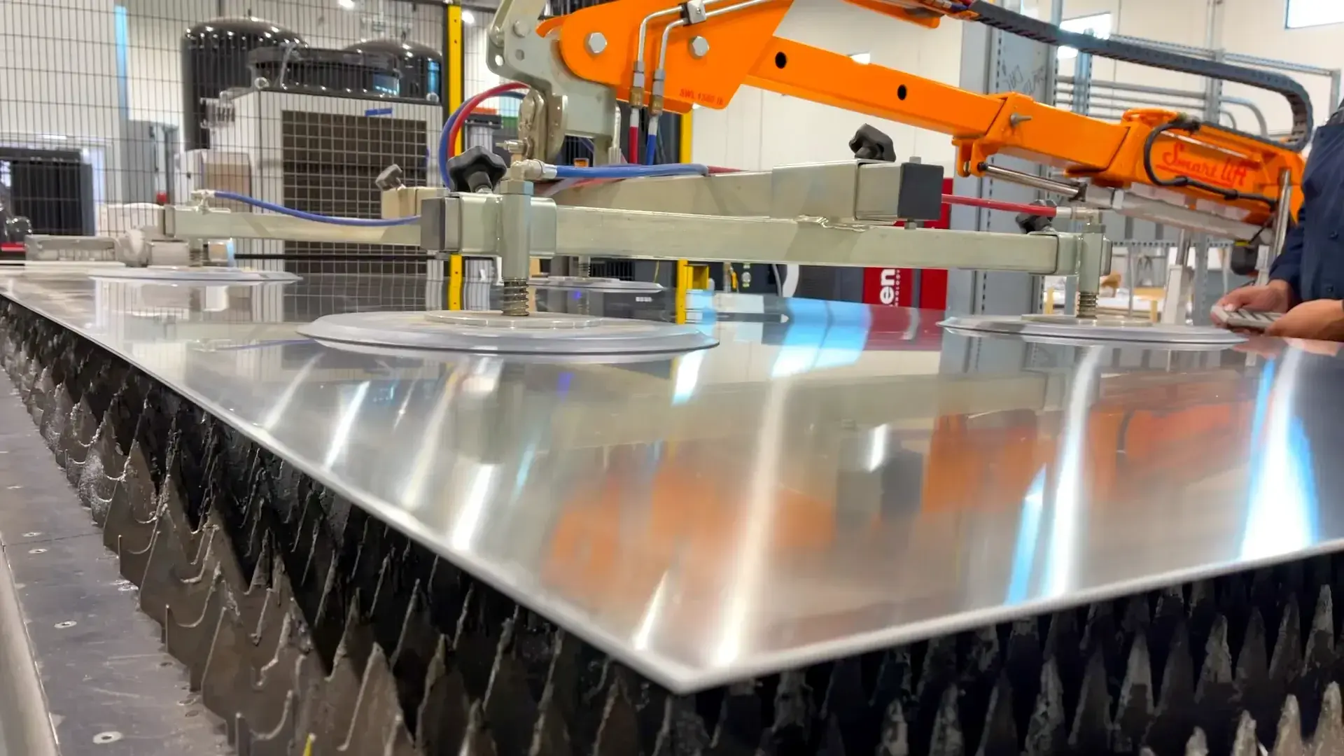 Robot lays the panel on the laser bed with precision